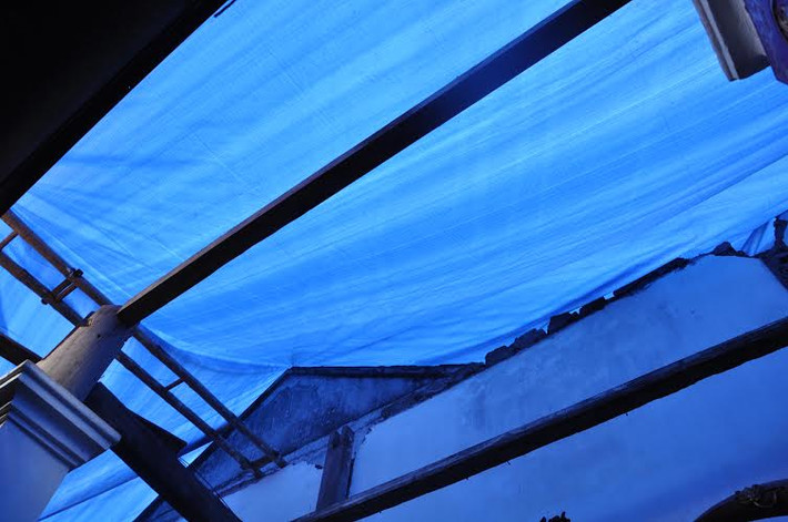 Mái đình sau khi được dỡ để lấy gỗ sưa bán, người ta đã phủ tấm bạt lên, nhìn rất phản cảm.