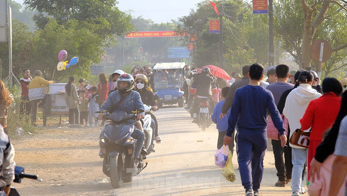 Nhiều du khách đi xe ô tô gửi ở bãi xe cách cổng khoảng 500m không đợi chờ được xe điện đã chọn cách đi bộ để kịp lên xe trở về chuẩn bị cho một năm mới lao động và học tập.