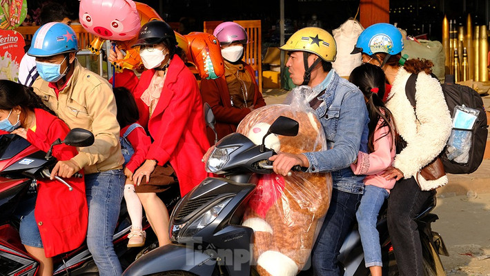 Nhiều gia đình trên hành trình về Hà Nội cũng đưa con ghé thăm suối cá thần. Đồ đạc lỉnh kỉnh chất đầy trên chiếc xe máy.