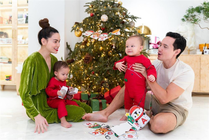 Gia đình Hà Hồ - Kim Lý cũng tranh thủ thực hiện bộ ảnh Noel quây quần. Trong khi Lisa và Leon mặc 2 bộ bodysuit tuần lộc màu đỏ, mẹ Hà Hồ mặc đầm nhung nhũ xanh lá chuẩn mùa lễ hội thì ba Kim Lý chẳng khác ngày thường là bao với áo phông, quần đùi.