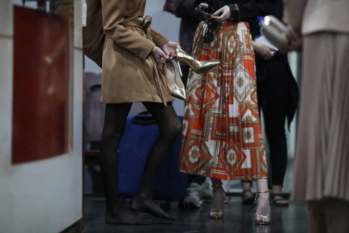 Đêm thứ hai của Vietnam International Fashion Week 2021 có 6 bộ sưu tập được trình diễn, do đó quãng thời gian chờ của người mẫu cũng lâu hơn. Nhiều người phải tháo giày cao gót, đứng trên chân trần vì mỏi và đau chân khi chờ lâu.