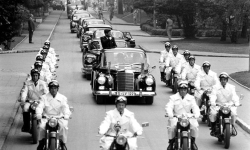 Tổng thống Kennedy vẫy tay chào người dân hai bên đường khi được một đoàn xe hộ tống hùng hậu bảo vệ trong chuyến thăm nước Đức năm 1963.