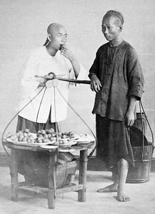 Hai người đàn ông Trung Quốc kiếm kế sinh nhai bằng việc bán hoa quả rong.