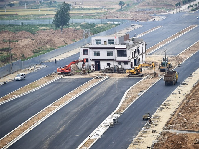 ột ngôi nhà nằm ở giữa tuyến đường đang thi công tại Trung Quốc. Được biết, tuyến đường vẫn xây dựng, còn chủ nhà từ chối việc di dời. (Nguồn: Reuters)