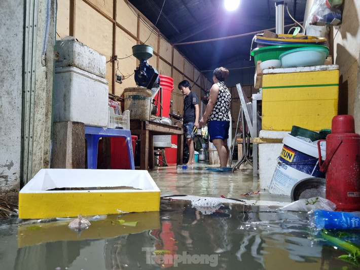 Nước tràn vào nhà dân rất nhanh. Các hộ dân tất bật cả tối dọn đồ đạc, kê gác những thiết bị điện lên để khỏi bị chập chạm.