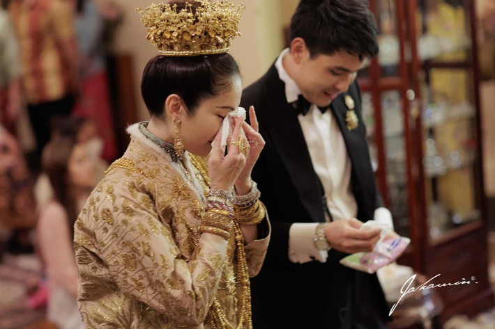 Cô dâu không kìm được nước mắt trong ngày trọng đại. Oak bên cạnh đã chuẩn bị khăn giấy đưa cho vợ.