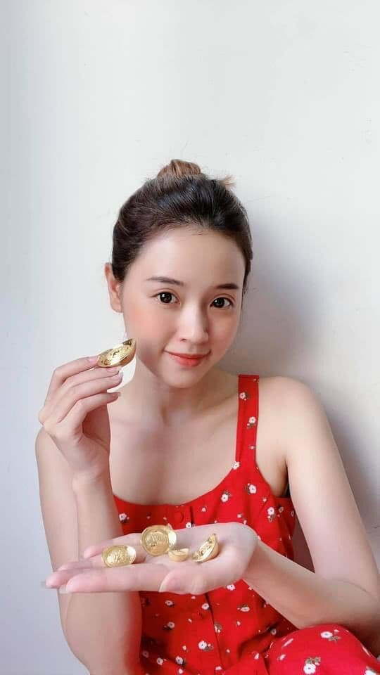 Midu diện trang phục đỏ tay cầm những thỏi vàng: "Ngày vía Thần Tài lấy mấy thỏi vàng xinh xinh ra đếm lấy hên".