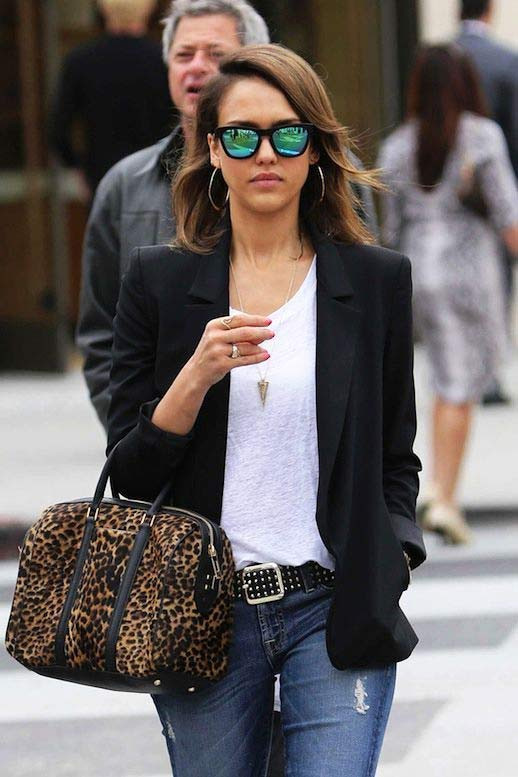Blazer đen khoác ngoài áo phông trắng, quần jeans mài trẻ trung và phụ kiện làm nổi bật trang phục là chiếc túi họa tiết da báo.
