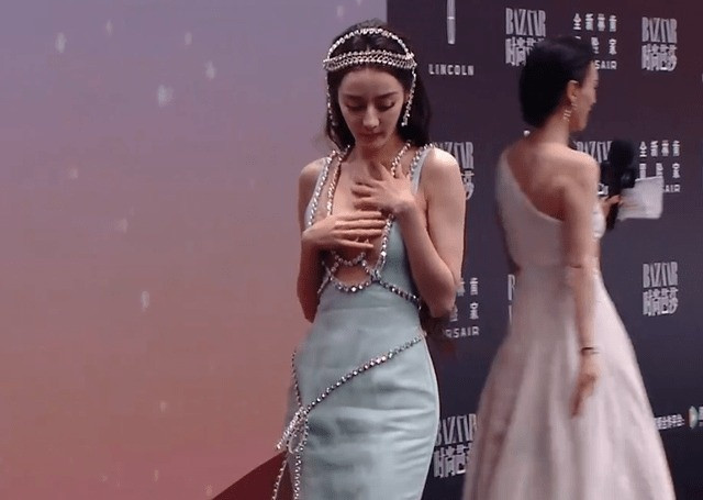 Trước hành động lấy tay che vòng một khi bước đi trên thảm đỏ của Địch Lệ Nhiệt Ba, nhiều ý kiến bình luận: "Cô ấy không nên mặc đồ như vậy nếu lần nào cũng phải dùng tay che ngực", "Nếu cô ấy ngại thì không nên mặc kiểu váy này", "Nhìn cô ấy khá rụt rè". Theo khán giả, nữ diễn viên thường xuyên có hành động này mỗi khi diện đồ gợi cảm. Ảnh: Sohu.