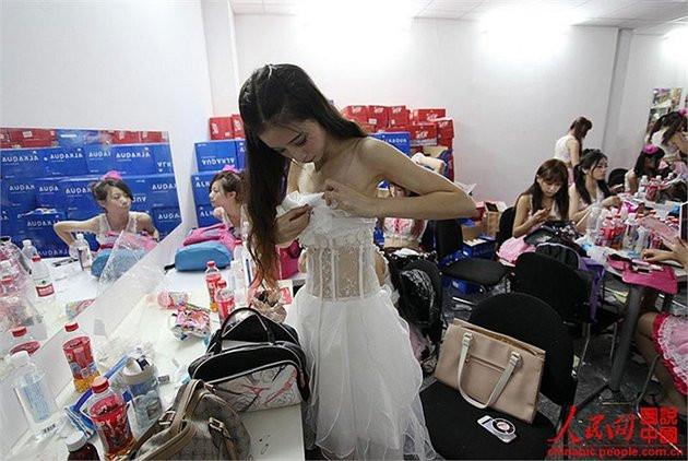 Quần áo đồng phục không vừa khít với người. Cô phải ghim lại để tránh sự cố tuột váy trong lúc nhảy múa, lắc mình.