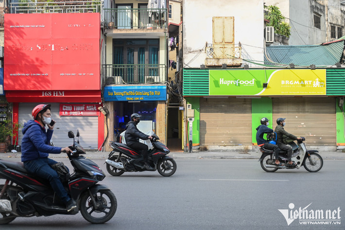 Dù đại dịch Covid-19 đã đi qua một thời gian, đến nay vẫn không ít mặt bằng trung tâm Hà Nội bị bỏ trống từ vài tháng đến cả năm. Trên phố Nguyễn Thái Học, hiện tượng nhiều cửa hàng kinh doanh cửa đóng, then cài xảy ra. Cứ cách từ một đến hai nhà, người đi đường dễ dàng gặp những tấm băng rôn dán số điện thoại treo ở mặt tiền.