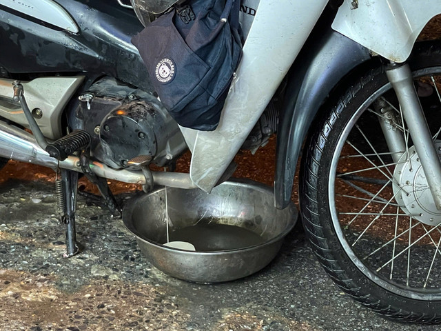 Một chiếc xe máy bị ngập nặng đang phải thay dầu vì nước ngập. 6-6809.jpg