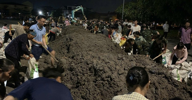Nhân dân không kể già trẻ, phối hợp với các lực lượng cùng nhau khẩn trương đắp đê ngăn nước lũ. 3.jpg