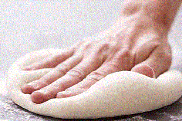 Dùng tay cán mỏng bột pizza thành cỡ đế mà bạn muốn, có thể tạo thành hình tròn hay hình trái tim theo sở thích rồi đem nướng sơ (khoảng 5') ở 220 độ C. (Ảnh: sdwingnuts.com)