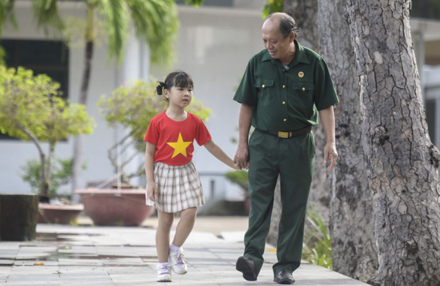 Thượng sĩ Nguyễn Chí Tường cùng con một nhân viên Vinamilk tại Trung tâm Điều dưỡng Thương binh và Người có công Long Đất (Ảnh: Thanh Bình). sua-v11.png