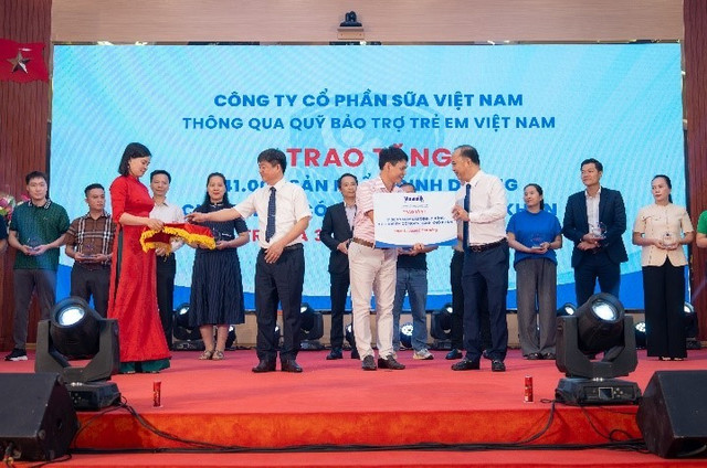 Ông Phạm Tuyên, Giám đốc chi nhánh Vinamilk Hà Nội (đứng giữa) trao bảng tượng trưng món quà 41.000 hộp sữa cho trẻ em Phú Thọ. m1.jpg