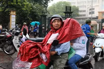 Xúc động cha mẹ đội mưa đưa con đi làm thủ tục dự thi