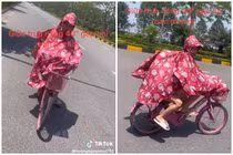 Đôi trẻ mặc áo mưa đi trong "chảo lửa" Hà Nội