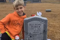 Cậu bé nhiều năm ngồi bên mộ kể chuyện cho em sinh đôi