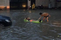 Khách Tây thả phao bơi giữa đường Sài Gòn sau mưa lớn