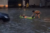 Khách Tây thả phao bơi giữa đường Sài Gòn sau mưa lớn