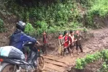 Học sinh lớp 1 kéo xe cho thầy qua đoạn đường khó 