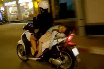 Đùa với tử thần: Mẹ chở con nằm ngủ sau xe máy
