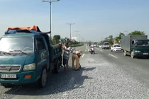 Cảnh sát giao thông dọn đá rơi vãi trên đường phố Sài Gòn