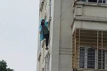 Cảnh sát giải cứu cô gái đu mình trên cửa sổ chung cư