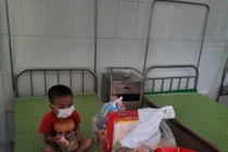 Bé trai 4 tuổi nghi mắc COVID-19 mặc đồ bảo hộ kín mít trong khu cách ly