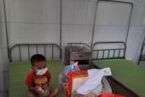 Bé trai 4 tuổi nghi mắc COVID-19 mặc đồ bảo hộ kín mít trong khu cách ly