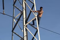 Hàng trăm người đứng xem giải cứu…người đàn ông leo cột điện cao thế