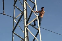 Hàng trăm người đứng xem giải cứu…người đàn ông leo cột điện cao thế