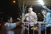 Cha chở 2 con trong lồng sắt rong ruổi khắp Sài Gòn mưu sinh