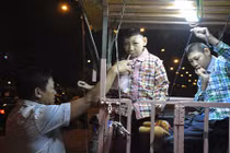 Cha chở 2 con trong lồng sắt rong ruổi khắp Sài Gòn mưu sinh