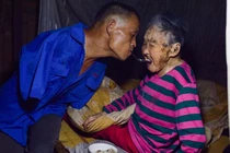 Ảnh đẹp mùa Vu Lan: Con cụt tay dùng miệng xúc cơm cho mẹ