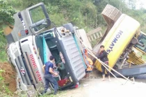 Xe đầu kéo chở máy xúc lật trên dốc, tài xế may mắn thoát nạn