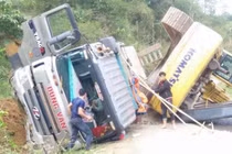 Xe đầu kéo chở máy xúc lật trên dốc, tài xế may mắn thoát nạn