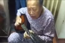 Cụ bà ôm đàn guitar hát một cách hào hùng