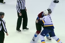 Hai cầu thủ đánh nhau, trọng tài đứng nhìn 