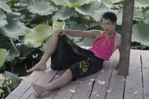 Chàng trai mặc áo yếm, cài hoa lên đầu tạo dáng gây sốc