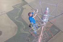 Ngồi vắt vẻo ở độ cao 450m thay bóng đèn