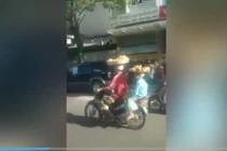 Vừa đội mẹt bánh vừa lái xe bon bon trên đường