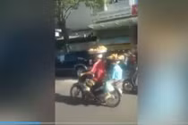 Vừa đội mẹt bánh vừa lái xe bon bon trên đường