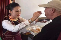 Nữ tiếp viên hàng không xinh đẹp bón cơm cho cụ già