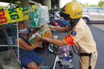 Hình ảnh CSGT TPHCM phát tờ rơi, tặng quà hỗ trợ người dân trong mùa dịch Covid-19.