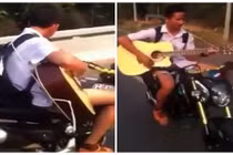 Gai mắt cảnh chàng trai vừa đi xe vừa đánh đàn