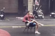 Thản nhiên đọc báo, uống trà trong siêu bão giữa đường phố