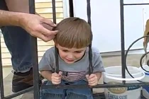 Khó tin bà mẹ thích thú khi con trai bị kẹt đầu vào song sắt