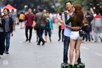 Ảnh nam nữ ôm nhau trượt xe điện thăng bằng bất chấp nguy hiểm